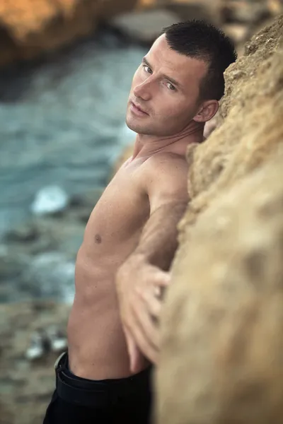 Attractive guy posing on rocks — 图库照片