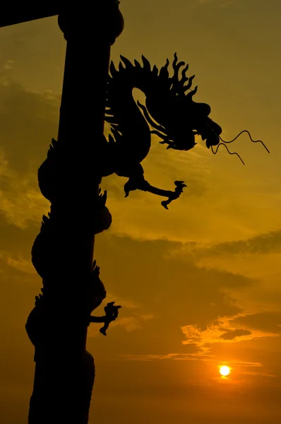 Ejderha heykeli siluet günbatımı gökyüzü ile — Stok fotoğraf