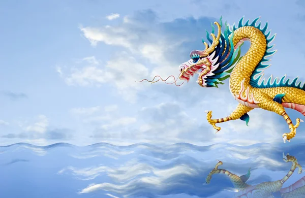 Zlatý drak letí nad mořem s pěknou oblohou na pozadí — Stock fotografie