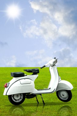 bahçedeki çimlerin üzerine beyaz retro vespa