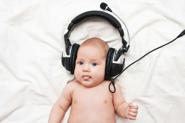 Adorable petite fille allongée dans des écouteurs — Photo