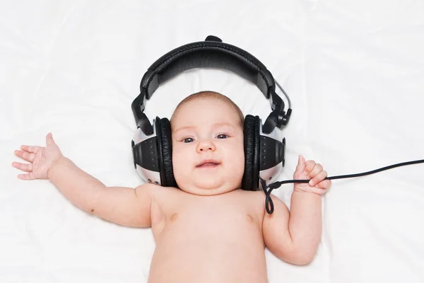 Adorable petite fille allongée dans des écouteurs — Photo