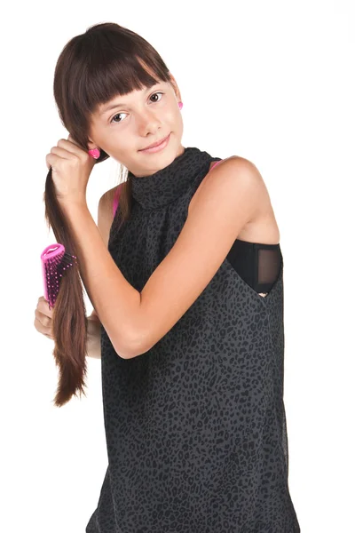Jonge brunette tiener kammen van lange haren op wit — Stockfoto