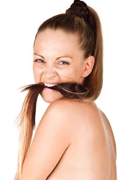 Молодая женщина кусает волосы — стоковое фото