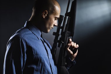 Handsome young man holding a gun. clipart