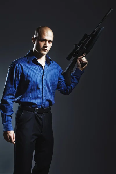 Stilig ung man håller en pistol — Stockfoto