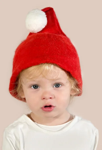 Smutne dziecko w czerwony kapelusz Świętego Mikołaja — Zdjęcie stockowe
