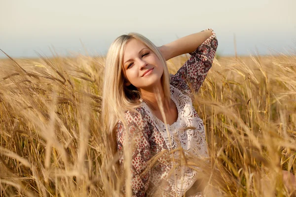 Woman sitting on wheat field — Stock Photo, Image