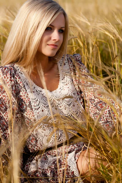 Žena sedí na pšeničné pole — Stock fotografie