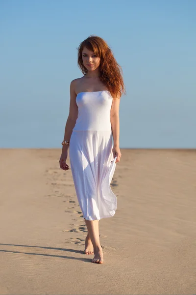 Женщина ходит по песку — стоковое фото