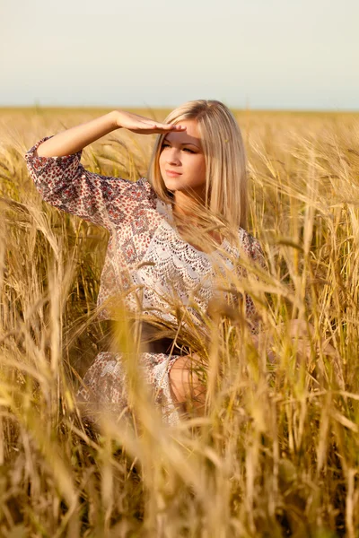 Frau sitzt auf Weizenfeld — Stockfoto