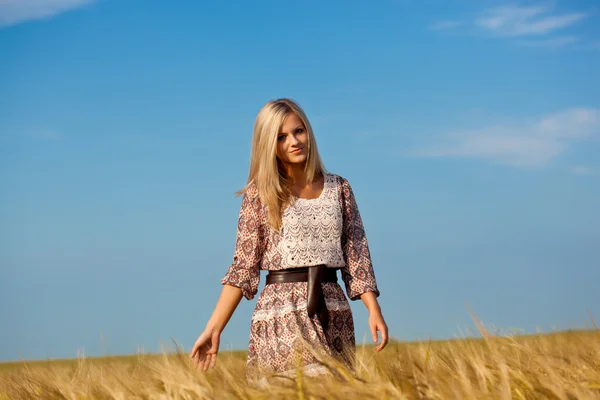 Kvinnan promenader på vete fält — Stockfoto