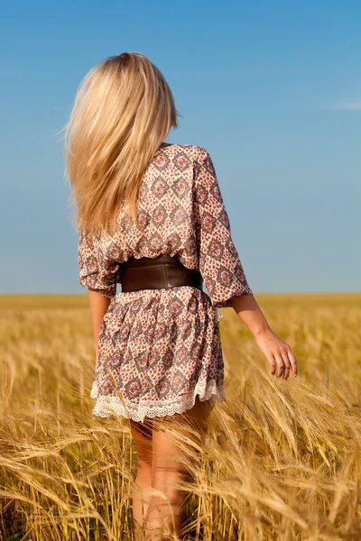 Женщина ходит по пшеничному полю — стоковое фото