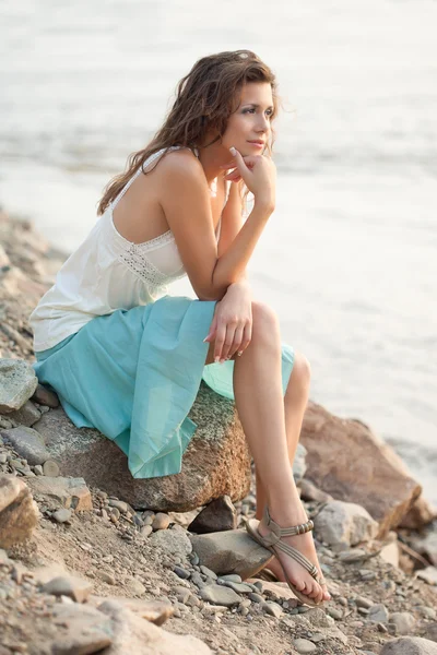 Piękna kobieta siedzi na kamieniu — Zdjęcie stockowe