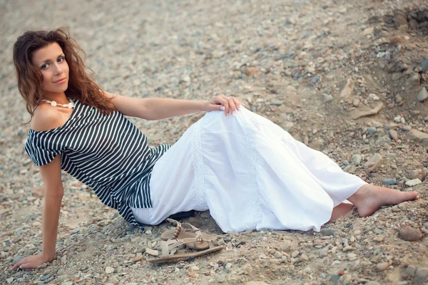 Brunetka kobieta siedzi na ziemi — Zdjęcie stockowe