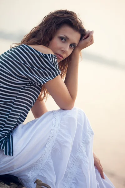 Atrakcyjna kobieta siedząca na plaży — Zdjęcie stockowe