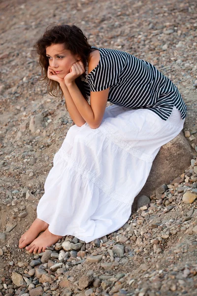 Žena sedí na kameni — Stock fotografie