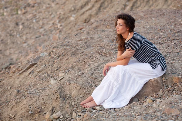 Morena sentada en la piedra — Foto de Stock