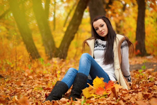 秋の公園で地面に座っている女性 — ストック写真