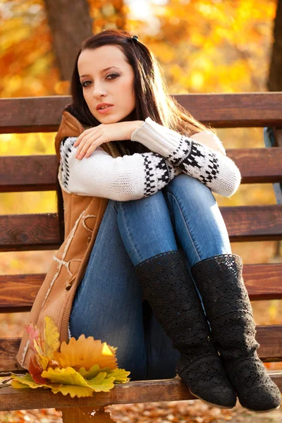Donna seduta su panchina marrone — Foto Stock