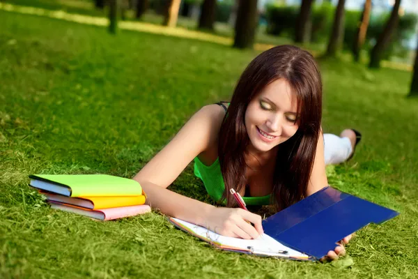 Vrouw tot vaststelling van op gras en schrijven — Stockfoto