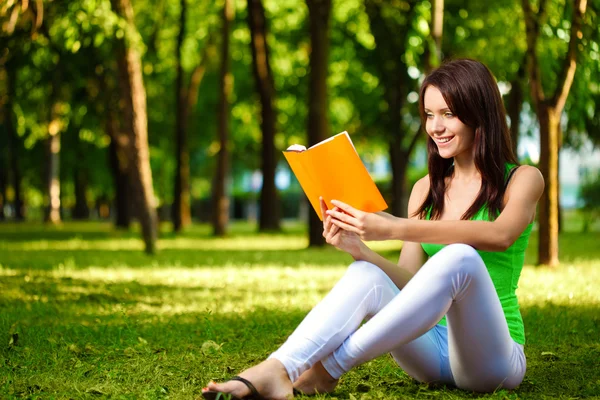 Женщина читает книгу и улыбается — стоковое фото