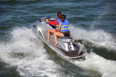 Young Ladies Riding on a Silver Jet-ski clipart