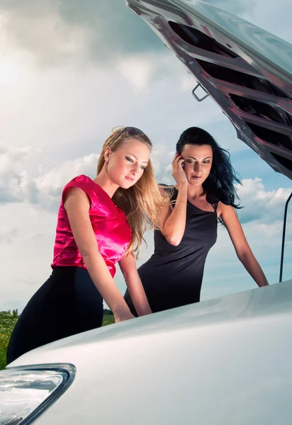 Dwóch młodych kobiet z uszkodzonego samochodu na drodze — Zdjęcie stockowe
