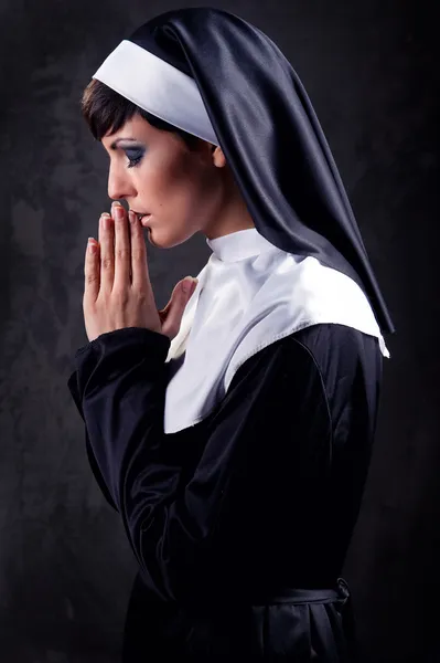 Молодая привлекательная монашка молится — стоковое фото