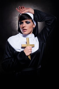 Young attractive nun holding a cross clipart