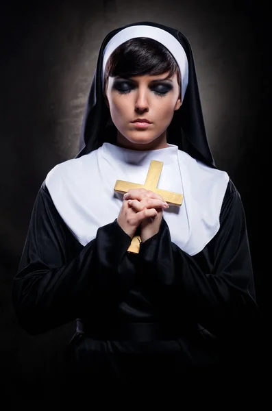Jovem freira atraente segurando uma cruz — Fotografia de Stock