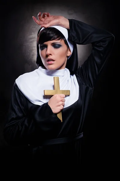 Joven monja atractiva sosteniendo una cruz — Foto de Stock