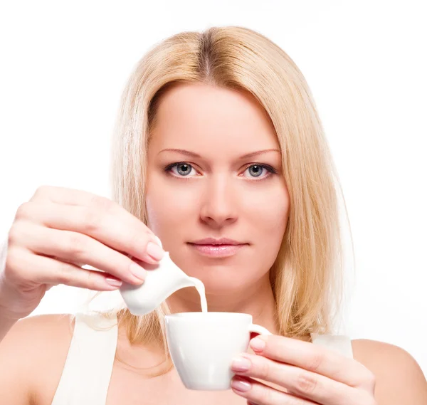 Frau gießt Sahne oder Milch in Tasse Kaffee — Stockfoto