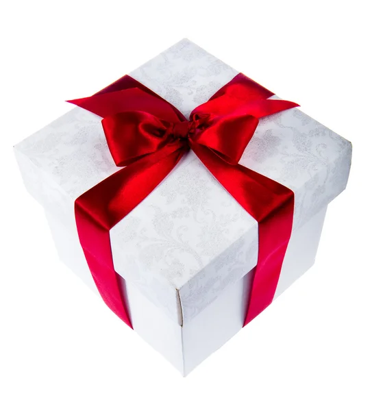White gift box decorated with red ribbon — Stock Photo, Image