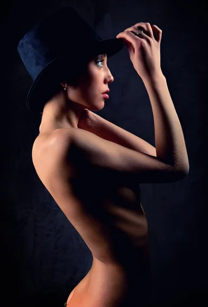 Beautiful woman wearing black hat posing indoors — Stock Photo, Image