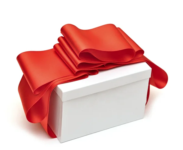 Ένα δώρο κόκκινη κορδέλα περιτυλίγματος σε λευκό — Φωτογραφία Αρχείου