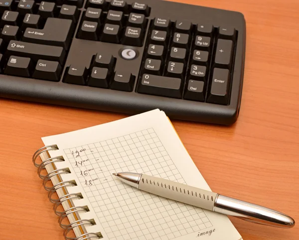 Notebook em branco no teclado preto — Fotografia de Stock