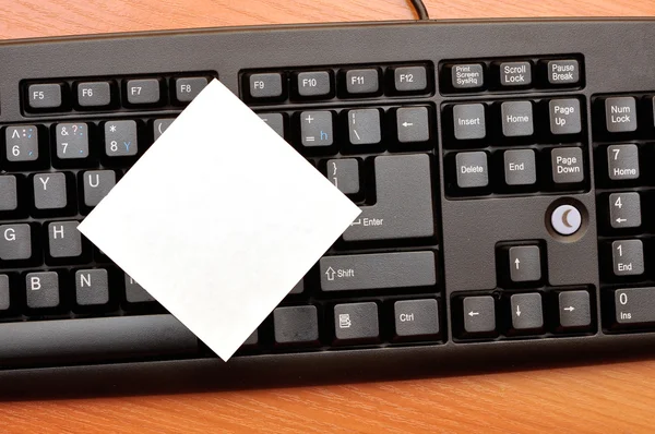 Prázdné dopisní papír na černá klávesnice — Stock fotografie