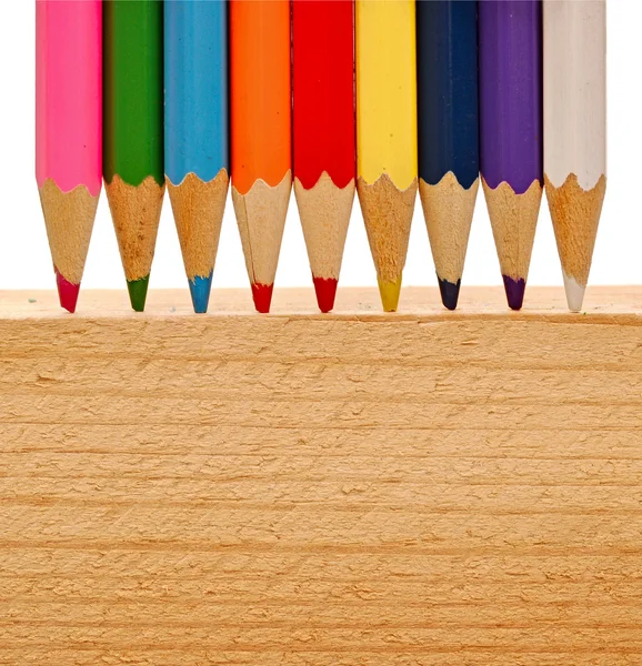 Barevné tužky na dřevo pozadí — Stock fotografie