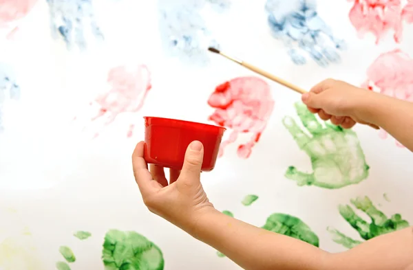 Childrens hand painting brush watercolors on a easel — Stock Photo, Image
