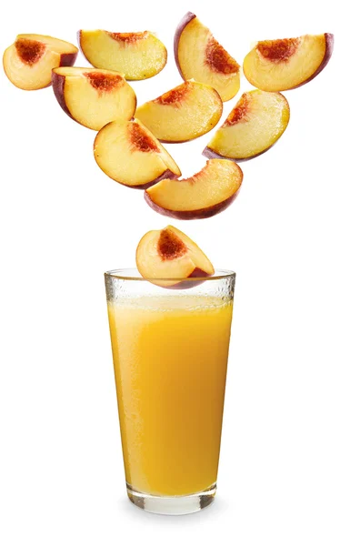 Персики падают в персиковый сок — стоковое фото