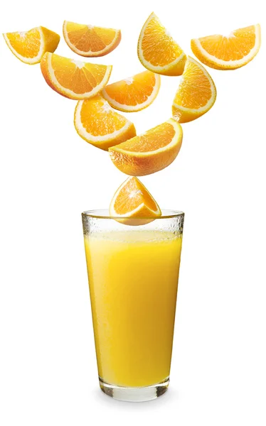 Апельсины падают в апельсиновый сок — стоковое фото