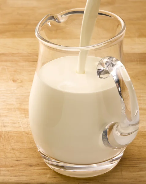 Ahşap masa üstünde süt kabı — Stok fotoğraf