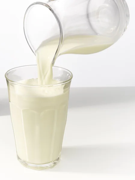 유리잔에 우유를 담그는 모습 — 스톡 사진