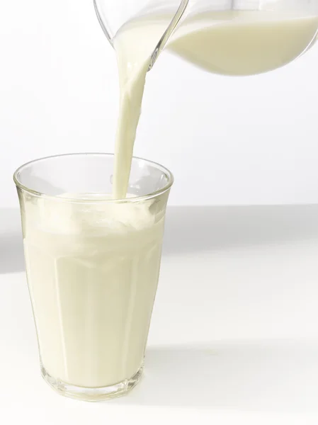 Milch in ein Glas gießen. — Stockfoto