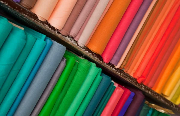 Estantes de textiles y telas de colores Fotos de stock
