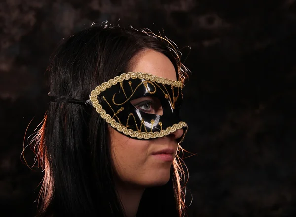 Fashion brunette girl with mask posing on dark background — Stock Photo, Image