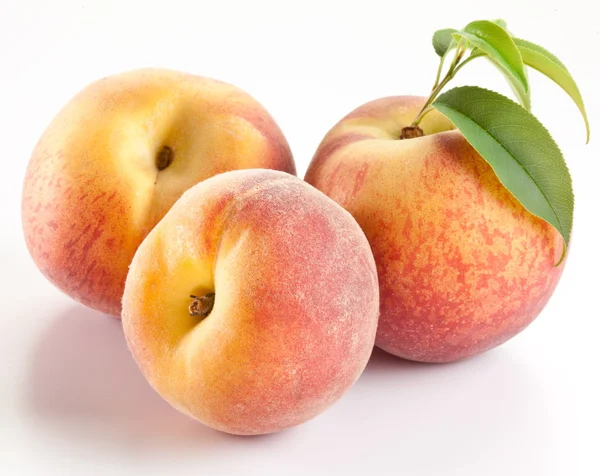 Reife Pfirsichfrüchte mit Blättern und Scheiben — Stockfoto