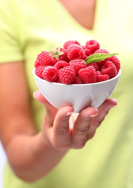 Crockery with raspberries in woman hand. — Stock Photo, Image
