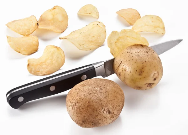 Obraz koncepcyjny - nóż tnie świeże ziemniaki i chipsach — Zdjęcie stockowe